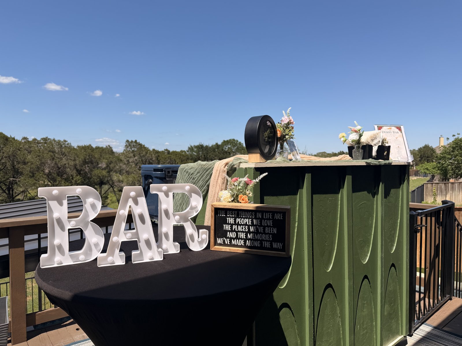 The green Sip N Social bar set up outdoors with a BAR sign